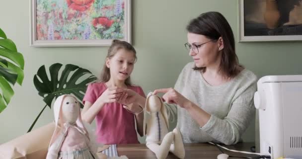 Mother and daughter child together sewing toy hare doll, hobbies and leisure at home - Materiał filmowy, wideo