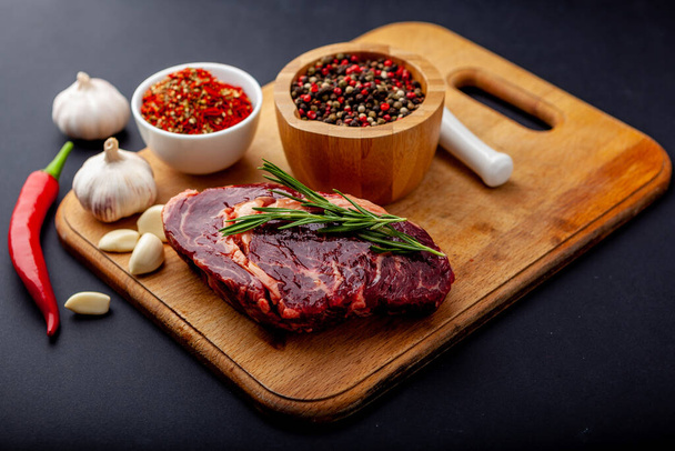 Steak frais avec un ensemble d'épices sur une planche à découper
 - Photo, image