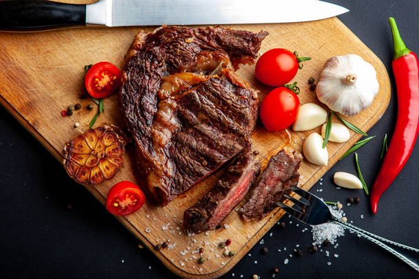 Friss, lédús bordás steak fűszerekkel a vágódeszkán - Fotó, kép