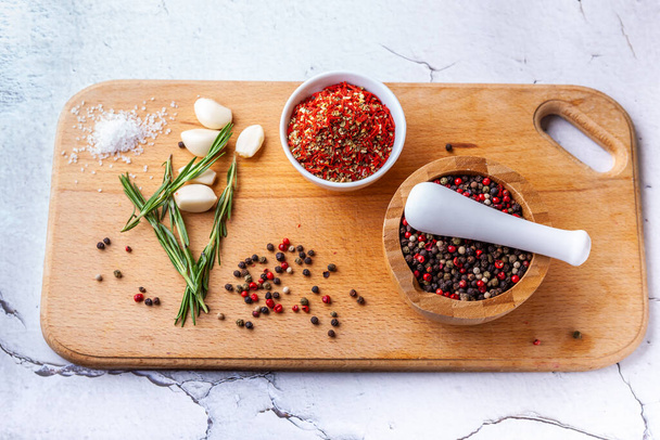 Set van kruiden hakken op een houten plank: rozemarijn, knoflook, peper, paprika - Foto, afbeelding