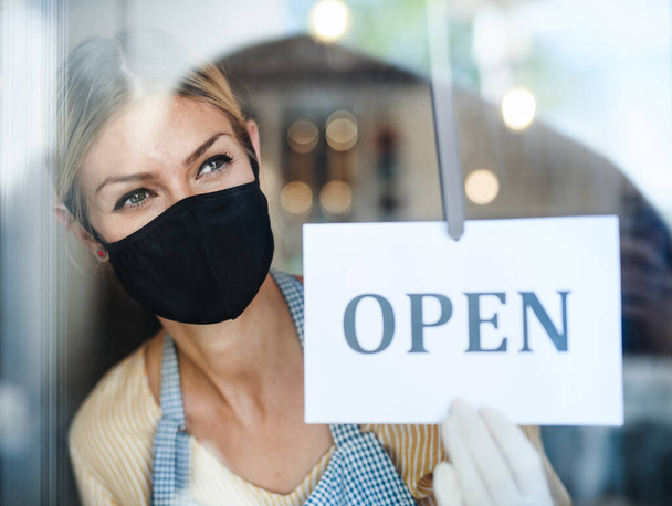 Coffee shop woman owner with face mask, open after lockdown quarantine. - Fotó, kép