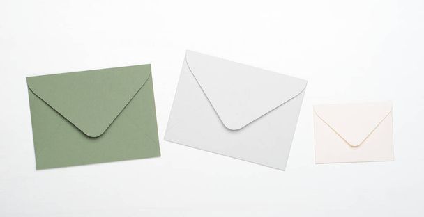 Envelopes verdes e brancos sobre fundo branco. Conceito de letras, mensagens, correspondência, espaço de cópia, vista superior, flat lay
 - Foto, Imagem