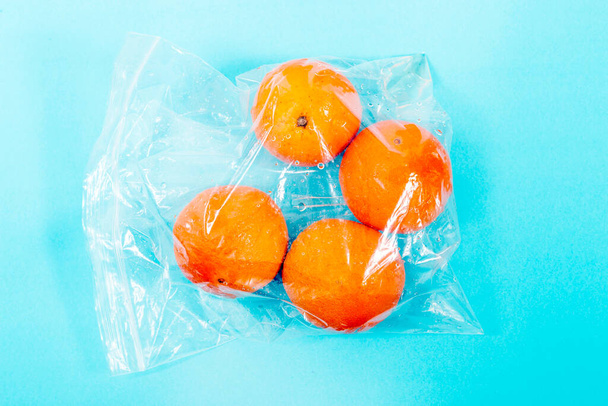 fresh organic oranges from the grocery market on a plastic bag. - 写真・画像