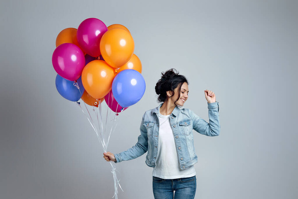 girl in denim posing with bright colorful air balloons - Foto, imagen