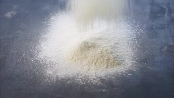 przesiewanie mąki do pieczenia przez sito na ciemnym stole - Materiał filmowy, wideo