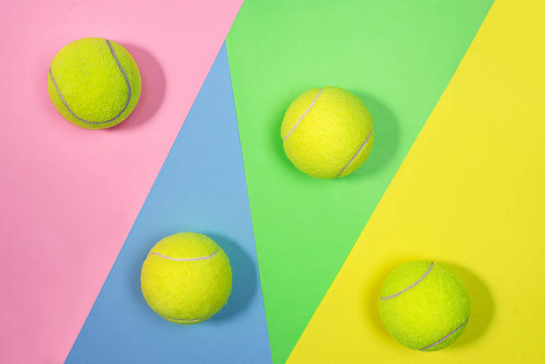 Tennis layout with tennis balls on abstract pastel pink blue yellow green background. - Фото, изображение