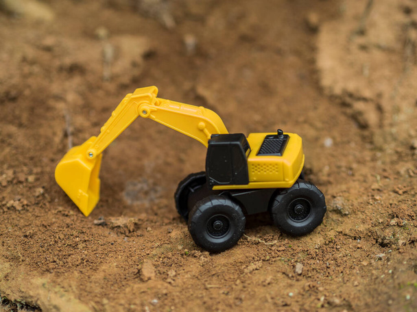 Speelgoedbouwmachines die werken aan een opgraving - Foto, afbeelding