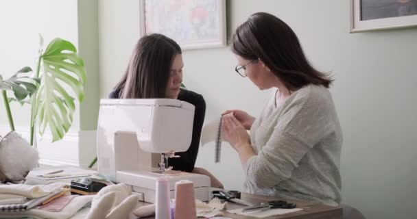  Mom teaching daughter sewing on machine, women sew toy and clothes for toy - Filmagem, Vídeo