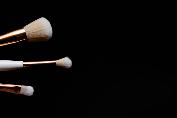 Makeup flat lay brushes on black background. Horizontal top view copyspace. Beauty and make up - Foto, Imagem