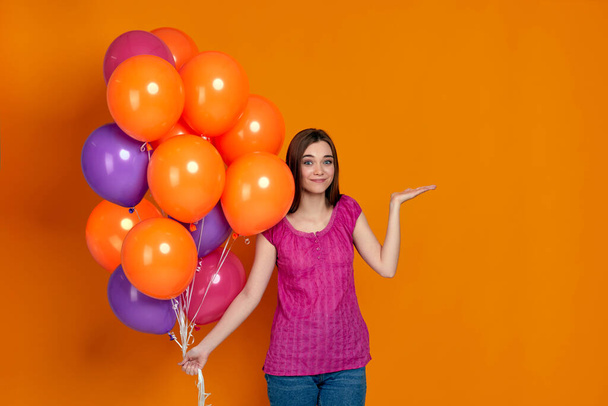 woman in pink t-shirt posing with bright colorful air balloons - Photo, Image