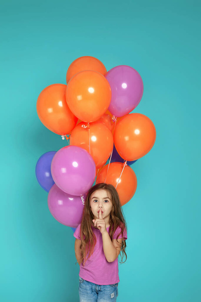 child girl in pink t-shirt posing with bright colorful air balloons - Фото, зображення