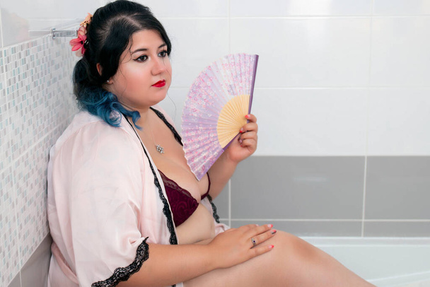 femme en peignoir rose sensuel et lingerie sur la baignoire
. - Photo, image