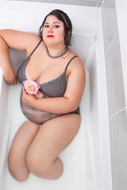 Nainen yllään aistillinen alusvaatteet maitomainen kylpyamme
. - Valokuva, kuva