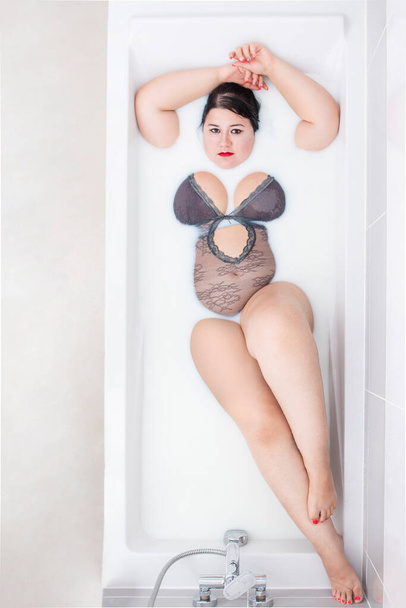 donna che indossa lingerie sensuale su una vasca da bagno lattiginosa
. - Foto, immagini