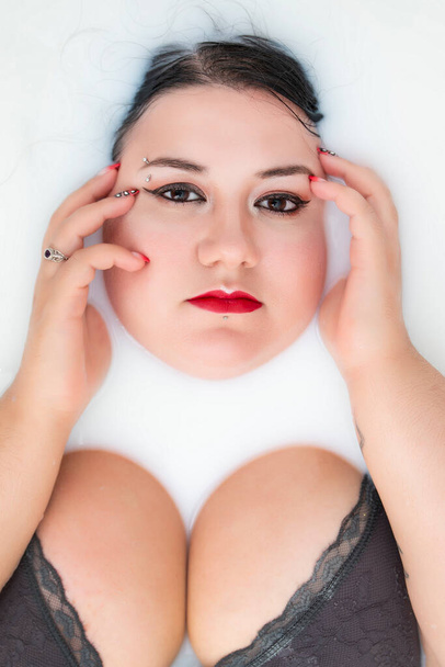 vrouw het dragen van sensuele lingerie op een melkachtig bad. - Foto, afbeelding