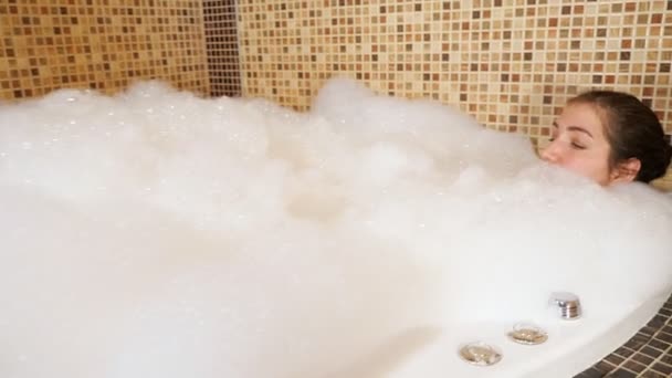 pretty brunette lies in bath with foam - Footage, Video