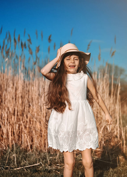 Aranyos mosolygós lány kalapban szórakozik a szabadban. - Fotó, kép