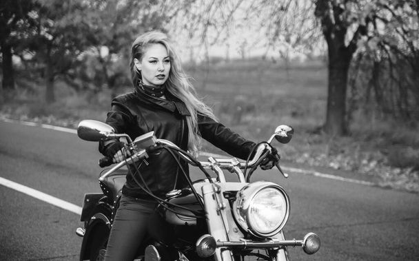 Woman posing with motorcycle outdoors. Black and white photo of beautiful biker woman. - Fotoğraf, Görsel