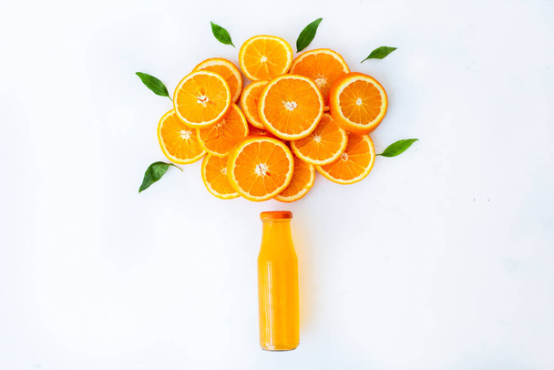 Jugo de naranja fresco con naranjas y rodajas de naranja sobre mesa blanca
 - Foto, imagen