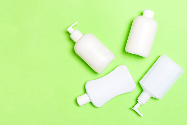 Set of White Cosmetic containers isolated on green background, top view with copy space. Group of plastic bodycare bottle containers with empty space for you design. - 写真・画像
