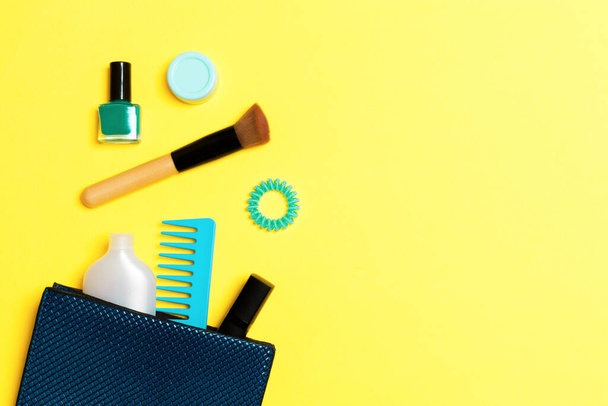 Maquillage produits débordant de sac cosmétique sur fond jaune avec espace vide pour votre design
. - Photo, image