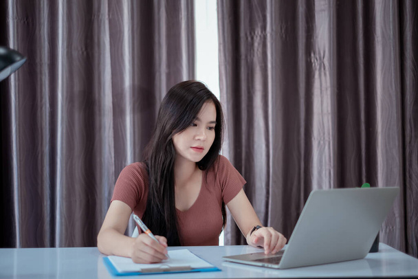 Asian woman working from home with laptop computer self isolation from society to reduce risk, quarantine prevention coronavirus, covid-19 and study e-learing online education technology concept. - 写真・画像