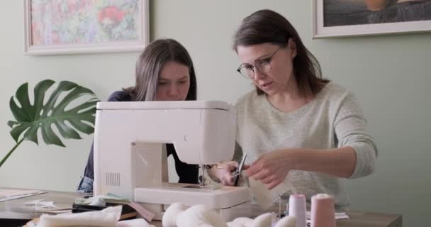 Mom teaching daughter sewing on machine, women sew toy and clothes for toy - Filmmaterial, Video