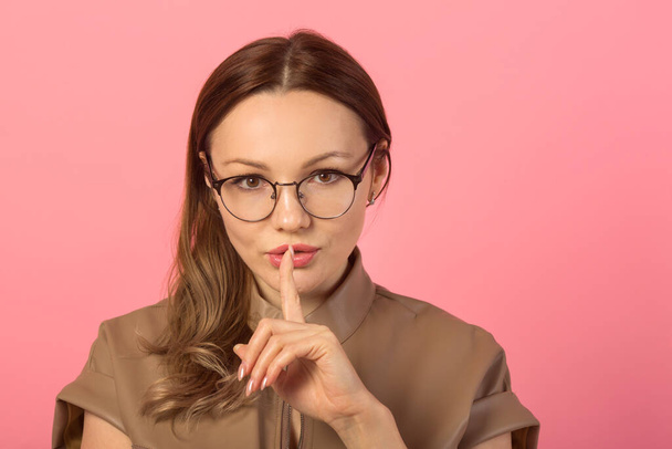  beautiful young woman in glasses on a pink background - Foto, afbeelding