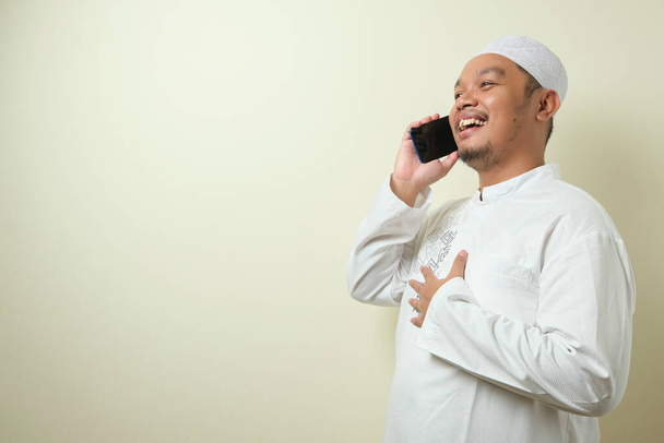 Hombre musulmán asiático se ve feliz cuando recibe una llamada de su hermano. El hombre celebró Eid Mubarak con gesto de confianza
 - Foto, Imagen