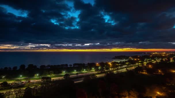 Un hermoso amanecer frente al lago aéreo al amanecer timelapse de Lake Shore conducir senderos semáforos como la noche se convierte en día con brillante horizonte naranja y amarillo y nubes azules por encima
. - Metraje, vídeo