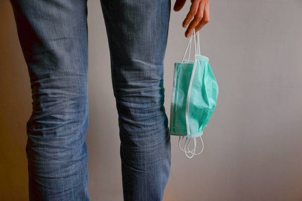 Girl in jeans with three surgical masks hanging in her right hand - Photo, Image