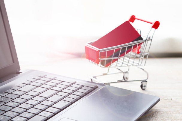 Laptop and shopping cart with a credit card. Online shopping. - Foto, Bild