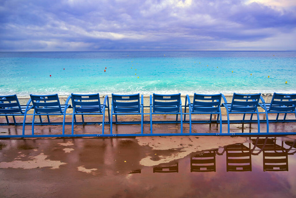 Γαλάζιες καρέκλες κατά μήκος του Promenade des Anglais στη Μεσόγειο Θάλασσα στη Νίκαια, Γαλλία κατά μήκος της Γαλλικής Ριβιέρας. - Φωτογραφία, εικόνα