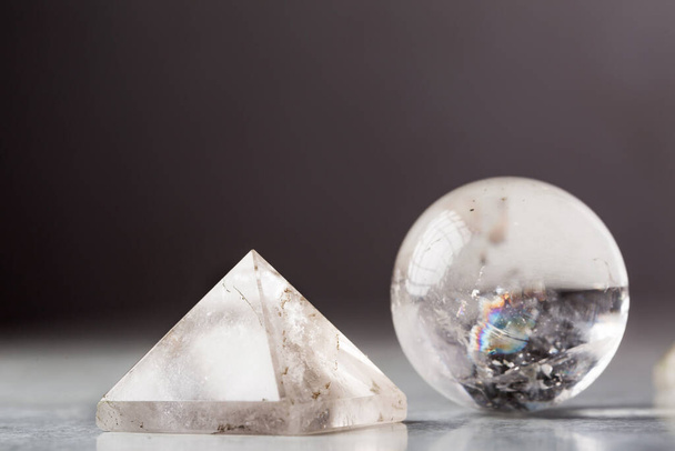 bola de cristal y pirámide de cristal de roca contra un fondo oscuro, concepto Reiki
 - Foto, Imagen