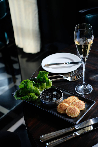 高級レストランでは、ブリニスとシャンパンで提供される黒のキャビア - 写真・画像