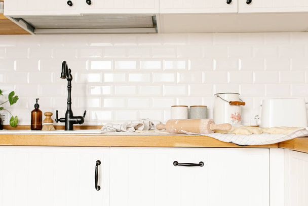 Fehér konyha kilátás rooling pin és főzés nélküli házi gombóc burgonyával a fa pult tetején. A varenyky pierogi hagyományos ukrán ételkészítésének folyamata - Fotó, kép