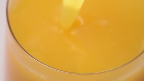 Giet sinaasappelsap in een glazen close-up, selectieve focus - Video