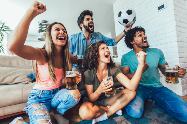 Bardzo podekscytowani przyjaciele dobrze się bawią oglądając mecz piłki nożnej i jedząc w domu, w domu. Przyjaźń, leasing, odpoczynek, koncepcja domowej imprezy - Zdjęcie, obraz