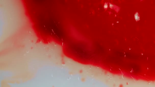 Kuva punaisesta tihkumisesta kuplien kanssa, lähikuva
 - Materiaali, video