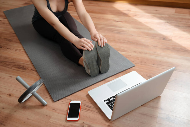Fitness coach geeft online yoga les. Workout trainer demonstreren stretching oefeningen voor studenten via videoconferentie. Thuistraining tijdens COVID-19 quarantaine. Flexibiliteit en sterkte - Foto, afbeelding