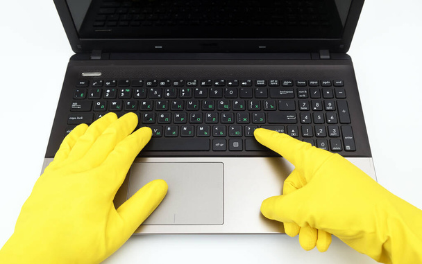 Disinfection in public places, the fight against the virus, coronavirus. A working hand in a rubber glove points to a keyboard. Spring general or regular cleaning.Danger of infection with the virus. - Fotografie, Obrázek