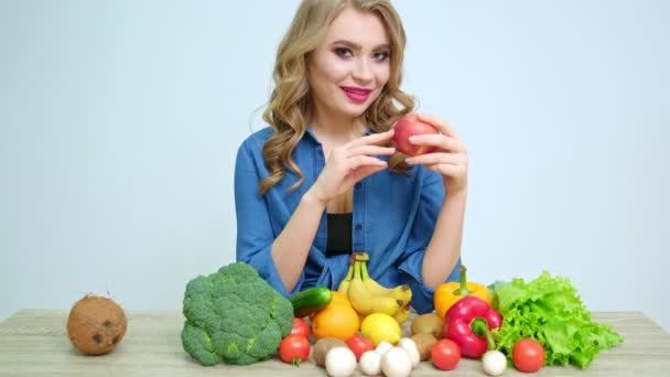 Mujer bonita en la cocina sosteniendo una manzana roja
 - Imágenes, Vídeo