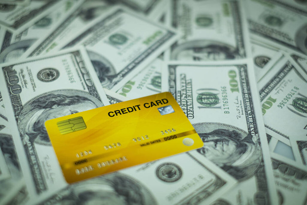 Primer plano de la tarjeta de crédito aislado en la pila de billetes de 100 USD fondo
 - Foto, imagen