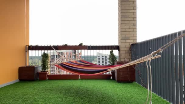 hermosa terraza - una hamaca se balancea en el viento, césped artificial verde en el suelo
 - Imágenes, Vídeo