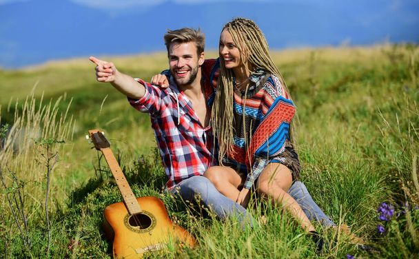 Feeling of love. happy friends with guitar. couple in love spend free time together. friendship. campfire songs. men play guitar for girl. western camping. hiking. country music. romantic date - Фото, изображение