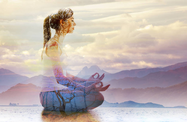Double exposure of silhouette of woman doing yoga in lotus position over lake landscape. Concept of connection with the universe and nature. - Фото, зображення