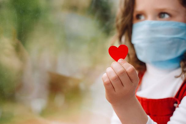 Nurse day concept. Small girl holding little red heart a way to show Thank your nurses thanking doctors and medical staff working in hospitals during coronavirus COVID-19 pandemics. Selective focus - Photo, image