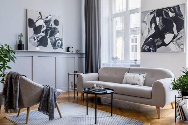 Elegante casa escandinava interior de la sala de estar con diseño sofá gris, sillón, taburete de mármol, mesa de centro negro, pinturas modernas, decoración, planta y elegantes accesorios personales en la decoración del hogar
. - Foto, imagen