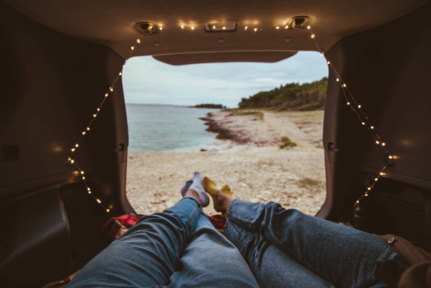 couple laying in the trunk of the car enjoying the view - Photo, image
