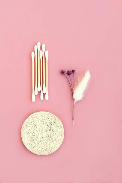 Bamboo cotton buds, a sponge from a natural loofah for the face on a pink background. - Фото, изображение